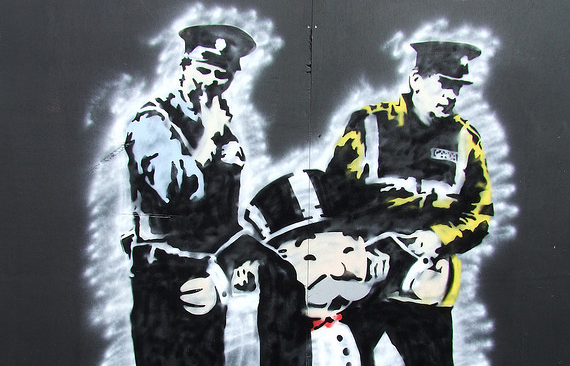 graffiti stencil of two gardai arresting the monopoly man