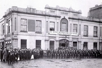 Irish Citizens Army in formation outside Liberty Hall. The banner reads 'we serve neither King nor Kaiser but Ireland'.