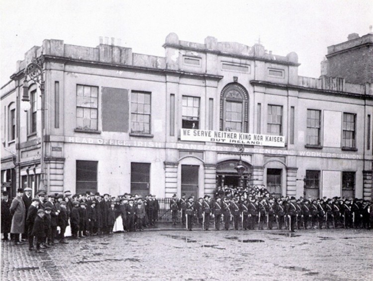 Irish Citizens Army in formation outside Liberty Hall. The banner reads 'we serve neither King nor Kaiser but Ireland'.