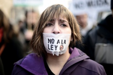 Woman protesting against the ley Mordaza, wearing a gag