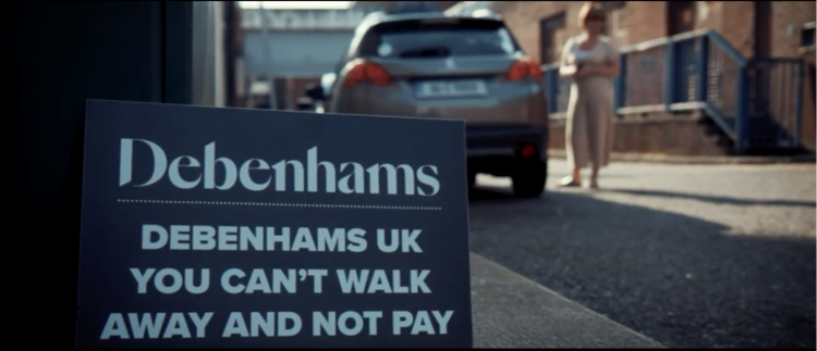 A placard at the Cork demonstration which reads "Demenhams UK you can't walk awayac and not pay"