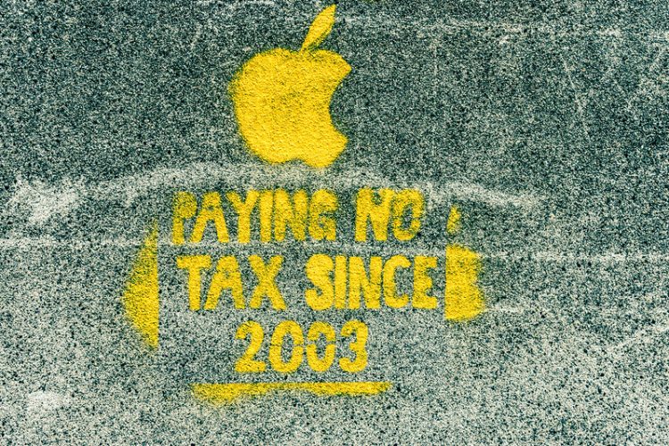 Photo of a spray painted image no Dublin street. There is an image of the Apple company logo and text saying "Paying no tax since 2003"