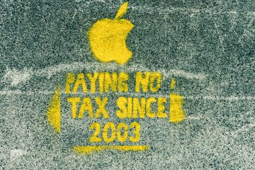 Photo of a spray painted image no Dublin street. There is an image of the Apple company logo and text saying "Paying no tax since 2003"